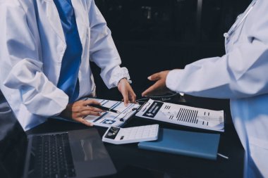 Dijital tablet sağlık doktoru teknolojisi tableti üzerinde çalışan tıbbi ekip hastanedeki tıbbi raporların sonuçlarını analiz etti..