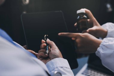 Dijital tablet sağlık doktoru teknolojisi tableti üzerinde çalışan tıbbi ekip hastanedeki tıbbi raporların sonuçlarını analiz etti..