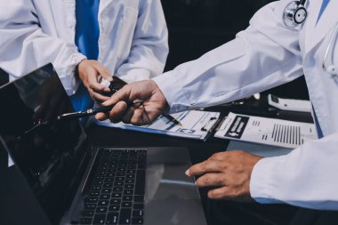 Dijital tablet sağlık doktoru teknolojisi tableti üzerinde çalışan tıbbi ekip hastanedeki tıbbi raporların sonuçlarını analiz etti..