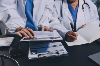 Dijital tablet sağlık doktoru teknolojisi tableti üzerinde çalışan tıbbi ekip hastanedeki tıbbi raporların sonuçlarını analiz etti..