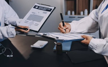 Hastane tıbbı çok etik insanlar grup toplantısı ekibi, aşı eğitimi için hemşire öğrencilerle klinik odasında konuşma. Tablet ve pano tutuluyor.