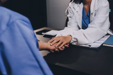 Nazik erkek doktor, beyaz önlüklü danışman yaşlı kadın hasta yaşlı kadının elini tutuyor. Yardım, güvenlik, empati ve destek veriyor, özen ve şefkat gösteriyor. Görüntüyü kapat