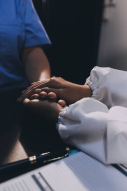 Nazik erkek doktor, beyaz önlüklü danışman yaşlı kadın hasta yaşlı kadının elini tutuyor. Yardım, güvenlik, empati ve destek veriyor, özen ve şefkat gösteriyor. Görüntüyü kapat