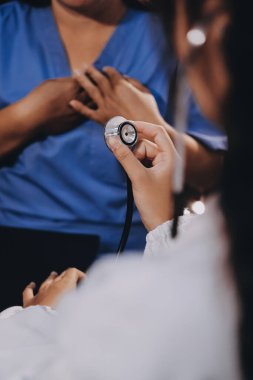 Kadın doktor kaba kalp atışı incelemek için stetoskop kullanın