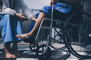 Yaşlı kadın hastanın bacağını iyileştirmek için fizyoterapi yapan fizyoterapist hemşire..