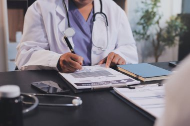 Güvenilir temsilci eczacılık hastanedeki doktor ve hemşire ekibine yeni ilaçlar gösteriyor. Bir grup doktora ilaç şişesini gösteren ve ilaç dozajını açıklayan yetişkin bir uzman..