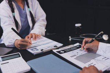 Güvenilir temsilci eczacılık hastanedeki doktor ve hemşire ekibine yeni ilaçlar gösteriyor. Bir grup doktora ilaç şişesini gösteren ve ilaç dozajını açıklayan yetişkin bir uzman..