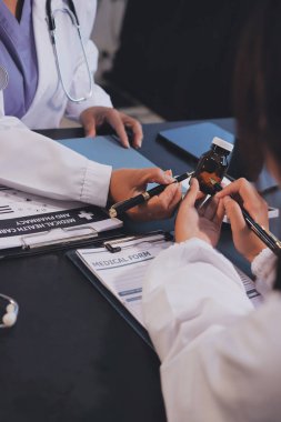 Güvenilir temsilci eczacılık hastanedeki doktor ve hemşire ekibine yeni ilaçlar gösteriyor. Bir grup doktora ilaç şişesini gösteren ve ilaç dozajını açıklayan yetişkin bir uzman..