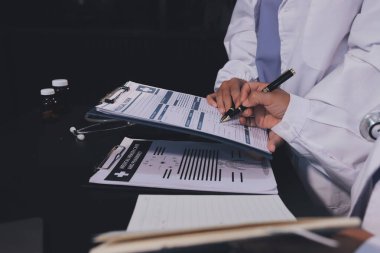 Dijital tablet sağlık doktoru teknolojisi tableti üzerinde çalışan tıbbi ekip hastanedeki tıbbi raporların sonuçlarını analiz etti..