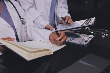 Dijital tablet sağlık doktoru teknolojisi tableti üzerinde çalışan tıbbi ekip hastanedeki tıbbi raporların sonuçlarını analiz etti..