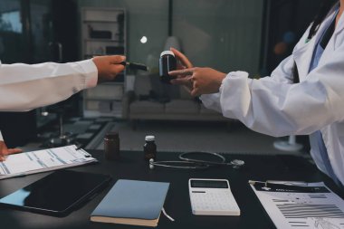 Hastane tıbbı çok etik insanlar grup toplantısı ekibi, aşı eğitimi için hemşire öğrencilerle klinik odasında konuşma. Tablet ve pano tutuluyor.