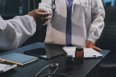 Hastane tıbbı çok etik insanlar grup toplantısı ekibi, aşı eğitimi için hemşire öğrencilerle klinik odasında konuşma. Tablet ve pano tutuluyor.