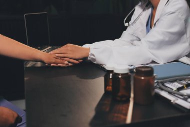 Nazik erkek doktor, beyaz önlüklü danışman yaşlı kadın hasta yaşlı kadının elini tutuyor. Yardım, güvenlik, empati ve destek veriyor, özen ve şefkat gösteriyor. Görüntüyü kapat