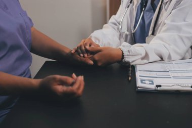 Nazik erkek doktor, beyaz önlüklü danışman yaşlı kadın hasta yaşlı kadının elini tutuyor. Yardım, güvenlik, empati ve destek veriyor, özen ve şefkat gösteriyor. Görüntüyü kapat