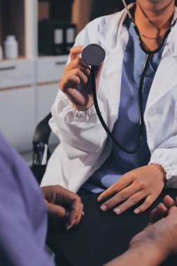 Kadın doktor kaba kalp atışı incelemek için stetoskop kullanın