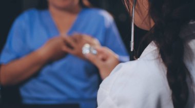 Kadın doktor kaba kalp atışı incelemek için stetoskop kullanın