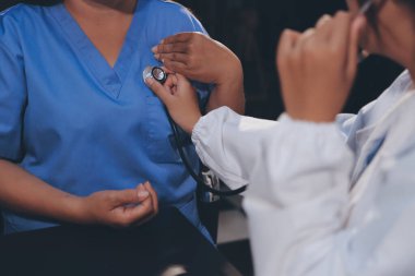 Kadın doktor kaba kalp atışı incelemek için stetoskop kullanın