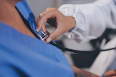 Kadın doktor kaba kalp atışı incelemek için stetoskop kullanın