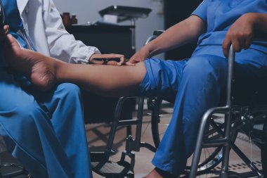 Yaşlı kadın hastanın bacağını iyileştirmek için fizyoterapi yapan fizyoterapist hemşire..