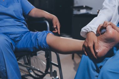 Yaşlı kadın hastanın bacağını iyileştirmek için fizyoterapi yapan fizyoterapist hemşire..