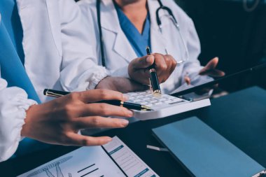 Dijital tablet sağlık doktoru teknolojisi tableti üzerinde çalışan tıbbi ekip hastanedeki tıbbi raporların sonuçlarını analiz etti..