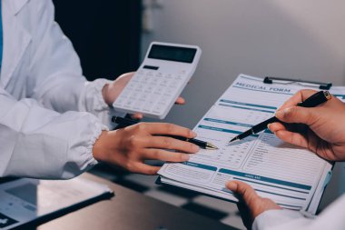 Hastane tıbbı çok etik insanlar grup toplantısı ekibi, aşı eğitimi için hemşire öğrencilerle klinik odasında konuşma. Tablet ve pano tutuluyor.