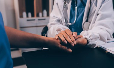 Nazik erkek doktor, beyaz önlüklü danışman yaşlı kadın hasta yaşlı kadının elini tutuyor. Yardım, güvenlik, empati ve destek veriyor, özen ve şefkat gösteriyor. Görüntüyü kapat