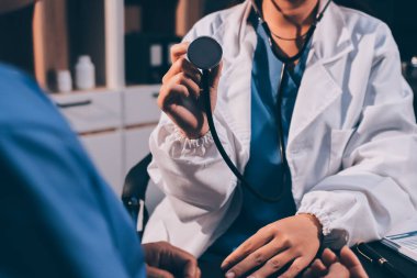 Kadın doktor kaba kalp atışı incelemek için stetoskop kullanın