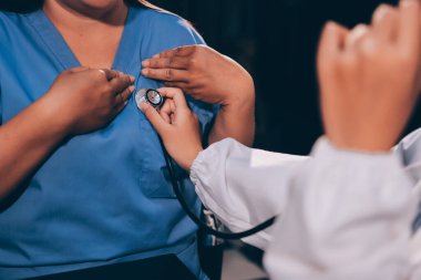 Kadın doktor kaba kalp atışı incelemek için stetoskop kullanın