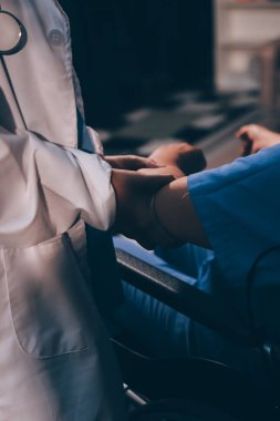 Doktor ya da fizyoterapist, sporcu erkek hastaların yaralı kollarını tedavi ediyor, esneme ve egzersiz yapıyor, klinikte rehabilitasyon tedavisi uyguluyor..