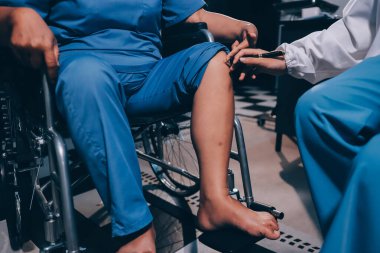 Yaşlı kadın hastanın bacağını iyileştirmek için fizyoterapi yapan fizyoterapist hemşire..