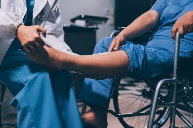 Yaşlı kadın hastanın bacağını iyileştirmek için fizyoterapi yapan fizyoterapist hemşire..