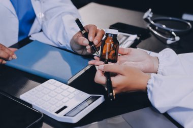 Güvenilir temsilci eczacılık hastanedeki doktor ve hemşire ekibine yeni ilaçlar gösteriyor. Bir grup doktora ilaç şişesini gösteren ve ilaç dozajını açıklayan yetişkin bir uzman..