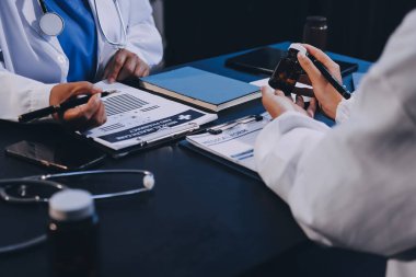 Güvenilir temsilci eczacılık hastanedeki doktor ve hemşire ekibine yeni ilaçlar gösteriyor. Bir grup doktora ilaç şişesini gösteren ve ilaç dozajını açıklayan yetişkin bir uzman..