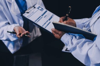 Dijital tablet sağlık doktoru teknolojisi tableti üzerinde çalışan tıbbi ekip hastanedeki tıbbi raporların sonuçlarını analiz etti..