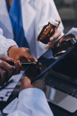 Dijital tablet sağlık doktoru teknolojisi tableti üzerinde çalışan tıbbi ekip hastanedeki tıbbi raporların sonuçlarını analiz etti..