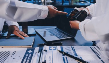 Dijital tablet sağlık doktoru teknolojisi tableti üzerinde çalışan tıbbi ekip hastanedeki tıbbi raporların sonuçlarını analiz etti..