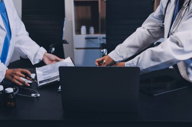 Hastane tıbbı çok etik insanlar grup toplantısı ekibi, aşı eğitimi için hemşire öğrencilerle klinik odasında konuşma. Tablet ve pano tutuluyor.