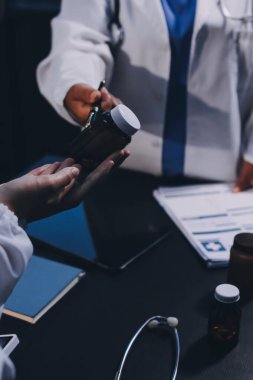 Hastane tıbbı çok etik insanlar grup toplantısı ekibi, aşı eğitimi için hemşire öğrencilerle klinik odasında konuşma. Tablet ve pano tutuluyor.