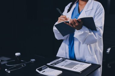 Hastane tıbbı çok etik insanlar grup toplantısı ekibi, aşı eğitimi için hemşire öğrencilerle klinik odasında konuşma. Tablet ve pano tutuluyor.