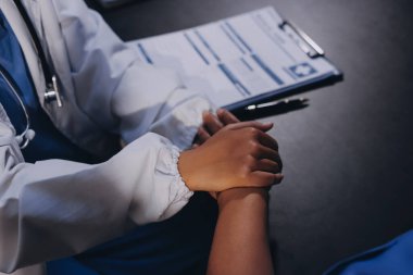 Nazik erkek doktor, beyaz önlüklü danışman yaşlı kadın hasta yaşlı kadının elini tutuyor. Yardım, güvenlik, empati ve destek veriyor, özen ve şefkat gösteriyor. Görüntüyü kapat