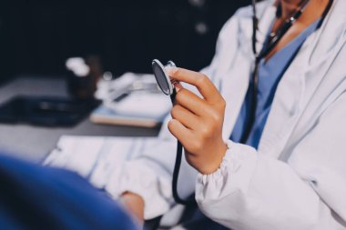 Kadın doktor kaba kalp atışı incelemek için stetoskop kullanın