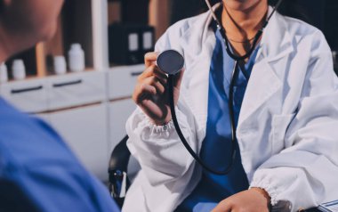 Kadın doktor kaba kalp atışı incelemek için stetoskop kullanın