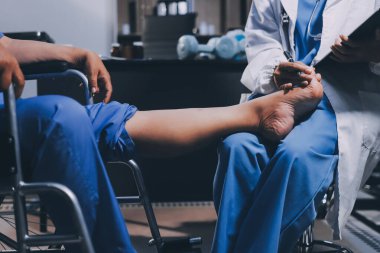 Yaşlı kadın hastanın bacağını iyileştirmek için fizyoterapi yapan fizyoterapist hemşire..