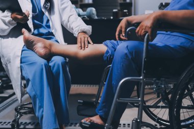 Yaşlı kadın hastanın bacağını iyileştirmek için fizyoterapi yapan fizyoterapist hemşire..