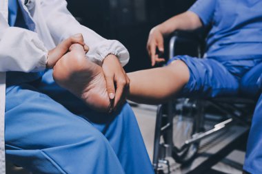 Yaşlı kadın hastanın bacağını iyileştirmek için fizyoterapi yapan fizyoterapist hemşire..