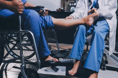 Yaşlı kadın hastanın bacağını iyileştirmek için fizyoterapi yapan fizyoterapist hemşire..