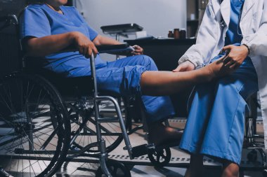 Yaşlı kadın hastanın bacağını iyileştirmek için fizyoterapi yapan fizyoterapist hemşire..