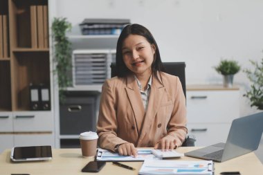 Ofiste dizüstü bilgisayarla çalışan Asyalı bir iş kadını..