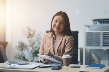 Ofiste dizüstü bilgisayarla çalışan Asyalı bir iş kadını..